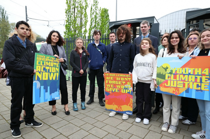 Ativistas climáticos seguram cartazes durante um comício perante o Tribunal Europeu dos Direitos Humanos
