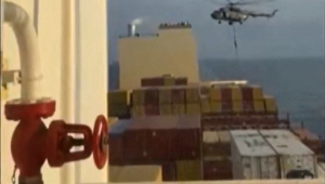 Esta imagem tirada de um vídeo UGC postado nas redes sociais em 13 de abril de 2023, mostra a Guarda Revolucionária do Irã descendo de rapel em um navio porta-contêineres chamado MSC Aries, perto do Estreito de Ormuz