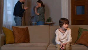 Criança pequena sofrendo abuso por pais brigando em casa
