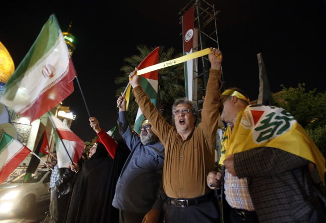 Pessoas seguram bandeiras iranianas e palestinas durante uma manifestação anti-Israel depois que o Irã lançou ataques de drones contra Israel