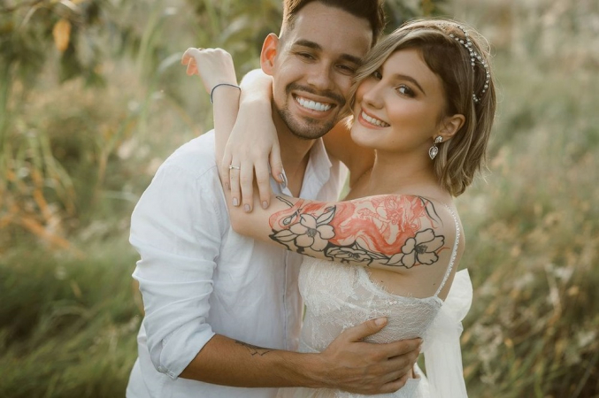 Isabela Veloso vestida de noiva e abraçada a seu noivo