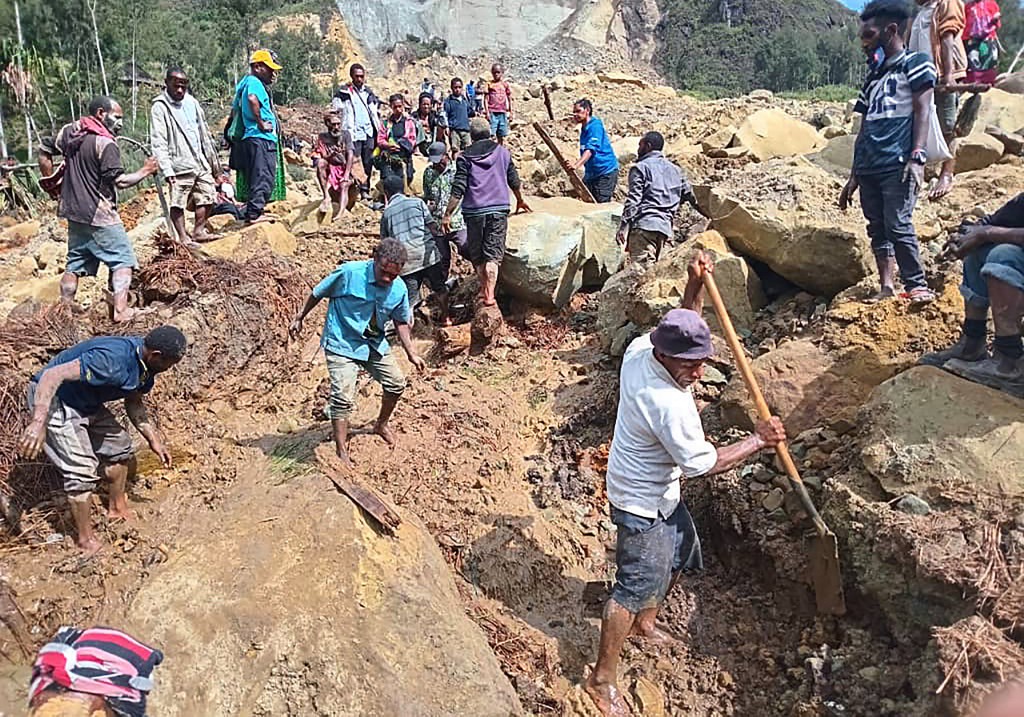 pessoas cavando no local de um deslizamento de terra na Vila de Yambali, na região de Maip Mulitaka, na Província de Enga, em Papua Nova Guiné
