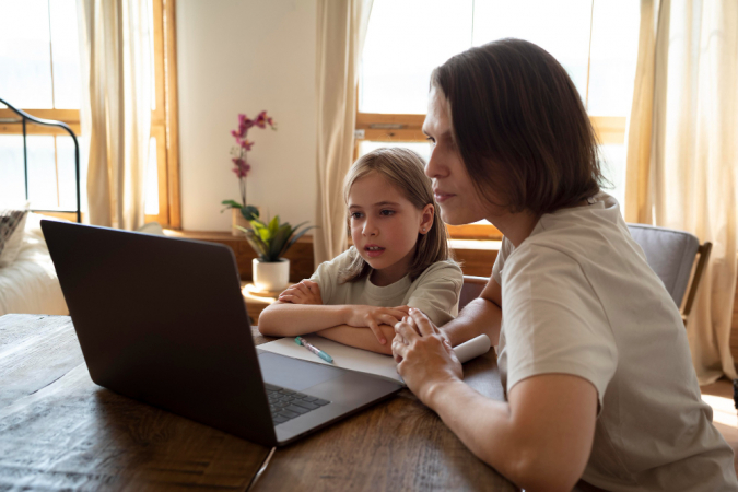 Mulher monitora criança com laptop