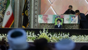 Um oficial iraniano beija o caixão do falecido presidente Ebrahim Raisi durante uma cerimônia fúnebre no santuário Imam Reza, em Mashhad