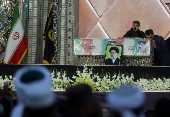 Um oficial iraniano beija o caixão do falecido presidente Ebrahim Raisi durante uma cerimônia fúnebre no santuário Imam Reza, em Mashhad