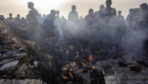 Palestinos inspecionam os danos após um ataque do exército israelense a um campo de deslocados em Rafah, ao sul da Faixa de Gaza