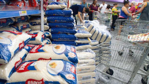 Movimentação de consumidores no corredor de arroz de um supermercado na zona norte de São Paulo
