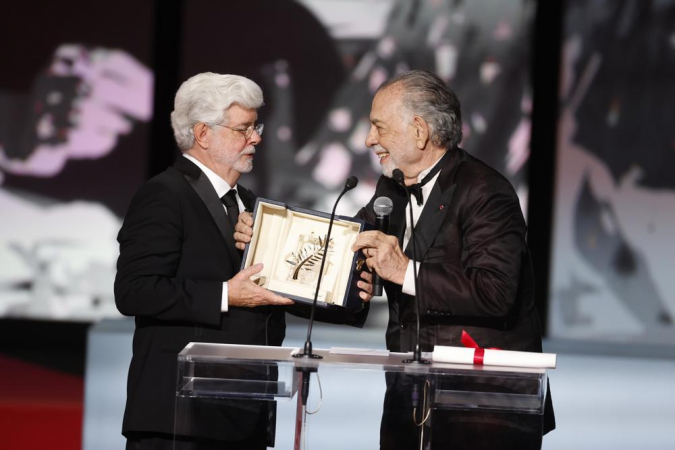 George Lucas (esq.) recebe o Prêmio Honorário Palma de Ouro de Francis Ford Coppola (dir.) durante a cerimônia de encerramento e premiação do 77º Festival Anual de Cinema de Cannes
