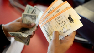 Mão segura dinheiro e volantes de loteria