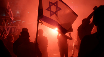 Um manifestante segura uma bandeira israelense durante um comício para pedir um acordo de reféns em Tel Aviv