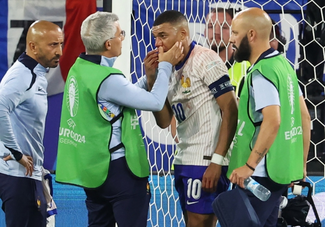 Kylian Mbappe (C) da França recebe cuidados médicos durante o jogo de futebol do grupo D do UEFA EURO 2024 entre Áustria e França