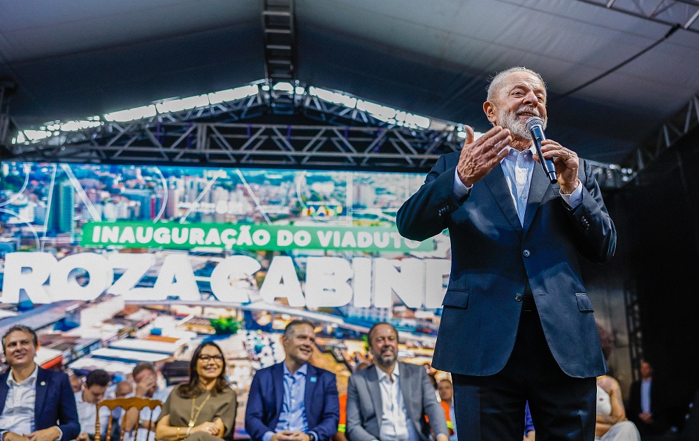 Lula, em pé no palco, discursa durante cerimônia de inauguração do Viaduto Roza Cabinda e de assinatura de Ordens de Serviço para recuperação de trechos da BR-267