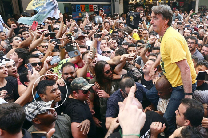 O candidato à presidência do Brasil, Jair Bolsonaro (PSL-RJ) é carregado nas costas por militantes durante ato político no Parque Halfeld de Juiz de Fora, em Minas Gerais. Detalhe no circulo, de Adelio Bispo de Oliveira, que desferiu uma facada ferindo o candidato.