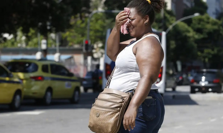 Mulher limpa suor da cara em dia de calor no Rio de Janeiro