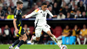 DEU - EUROCOPA/ALEMANHA X ESCÓCIA - ESPORTES - Jamal Musiala, da Alemanha, disputa a bola com Ryan Christie, da Escócia, em partida válida pela 1ª rodada do Grupo A da Eurocopa 2024, na Allianz Arena, em Munique, na Alemanha, nesta sexta-feira (14).