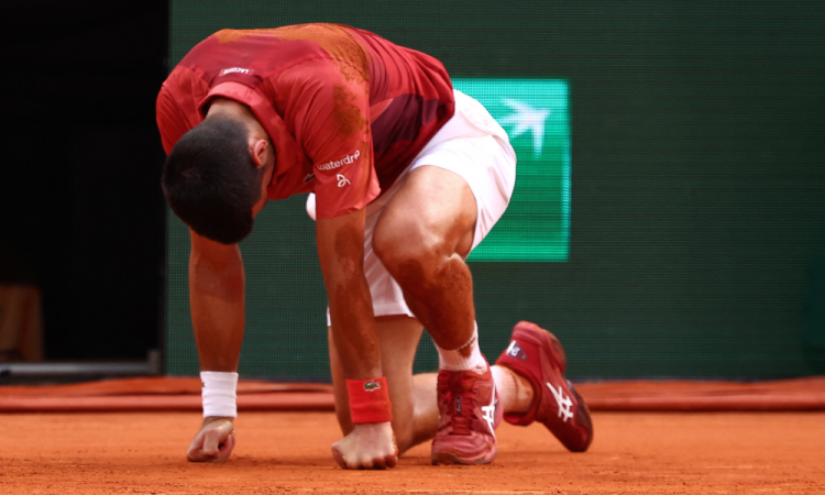 O sérvio Novak Djokovic reage depois de cair na quadra durante a partida individual masculina das oitavas de final contra o argentino Francisco Cerundolo na quadra Philippe-Chatrier no nono dia do torneio de tênis do Aberto da França no Complexo Roland Garros em Paris, em 3 de junho de 2024.