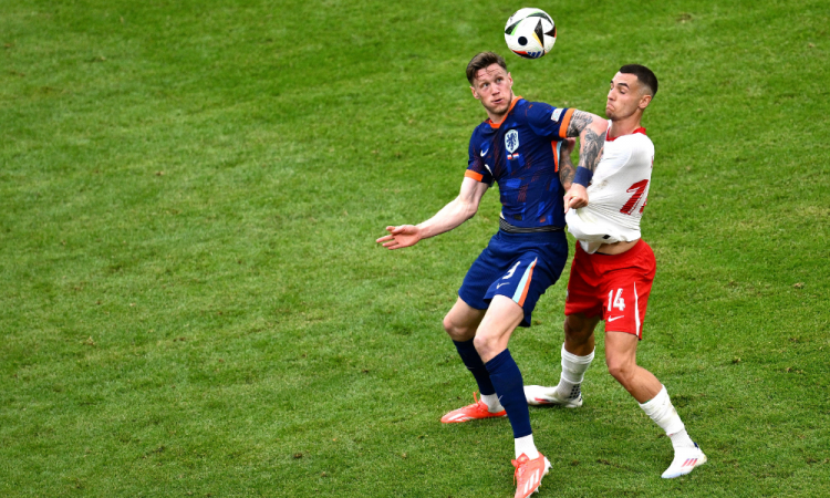 O atacante holandês # 09 Wout Weghorst (L) luta pela bola com o zagueiro polonês # 14 Jakub Kiwior durante a partida de futebol do Grupo D da UEFA Euro 2024 entre a Polônia e a Holanda, no Volksparkstadion, em Hamburgo, em 16 de junho de 2024.