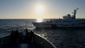 Esta foto tirada em 5 de março de 2024 mostra jornalistas filmando enquanto um navio da Guarda Costeira da China (R) navega em frente ao BRP Sindangan durante uma missão de abastecimento ao Second Thomas Shoal, no disputado Mar do Sul da China. O governo filipino acusou navios chineses de abalroar e danificar os seus barcos no Mar da China Meridional durante um confronto nas águas ao largo do Second Thomas Shoal, lar de uma guarnição de tropas filipinas.