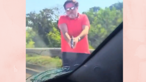 Homem aponta arma para carro