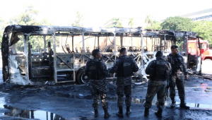 Policiais do Batalhão de Operações Especiais (Bope) inspecionam o local onde um ônibus foi incendiado, na altura do Edifício da Fiocruz, na Avenida Brasil, no Rio de Janeiro