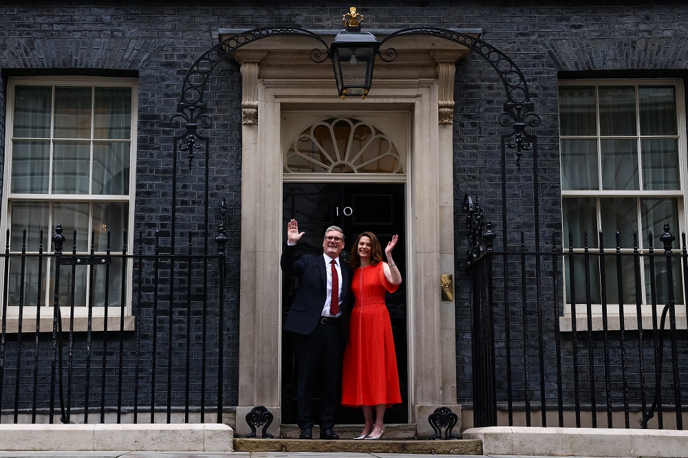 O novo primeiro-ministro britânico e líder do Partido Trabalhista, Keir Starmer, e sua esposa Victoria, acenam enquanto posam nos degraus da 10 Downing Street, em Londres