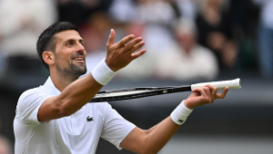 O sérvio Novak Djokovic imita tocar violino com sua raquete enquanto comemora a vitória contra o italiano Lorenzo Musetti