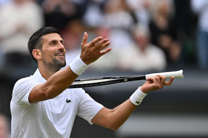 O sérvio Novak Djokovic imita tocar violino com sua raquete enquanto comemora a vitória contra o italiano Lorenzo Musetti