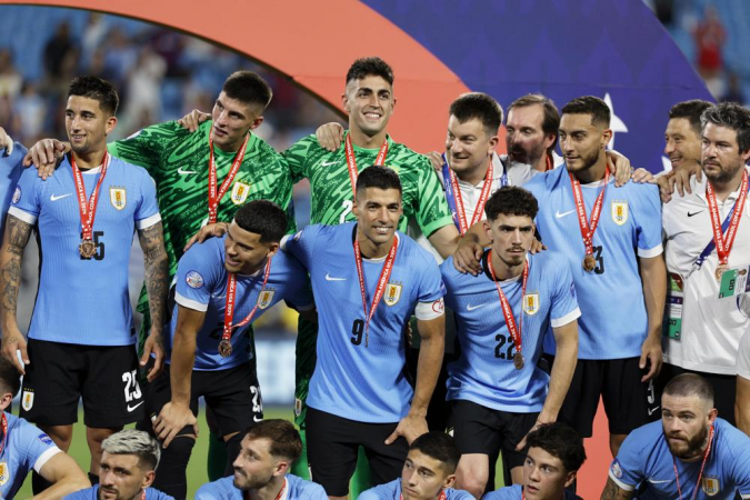 O capitão da seleção uruguaia Luis Suarez (9) e seus companheiros posam no pódio de premiação após derrotar o Canadá na disputa pelo terceiro lugar