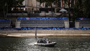Um barco passa por uma tribuna vazia instalada para a cerimônia dos Jogos Olímpicos em Paris