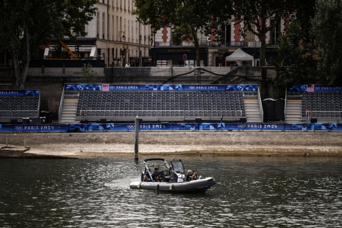 Um barco passa por uma tribuna vazia instalada para a cerimônia dos Jogos Olímpicos em Paris