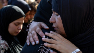Palestinos choram ao lado dos corpos de seus parentes mortos após um ataque israelense que atingiu uma escola que abrigava deslocados em Khan Yunis