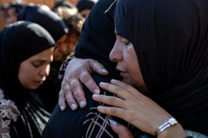 Palestinos choram ao lado dos corpos de seus parentes mortos após um ataque israelense que atingiu uma escola que abrigava deslocados em Khan Yunis