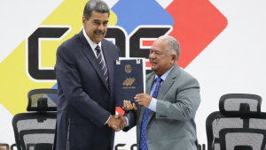 O presidente da Venezuela, Nicolás Maduro (esq.), e o presidente do Conselho Nacional Eleitoral (CNE), Elvis Amoroso, seguram o documento de posse do presidente eleito