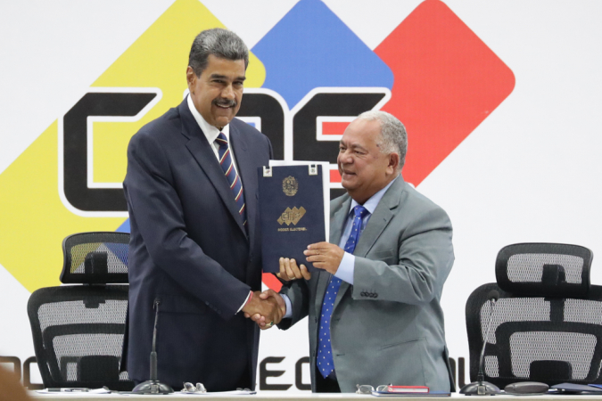 O presidente da Venezuela, Nicolás Maduro (esq.), e o presidente do Conselho Nacional Eleitoral (CNE), Elvis Amoroso, seguram o documento de posse do presidente eleito