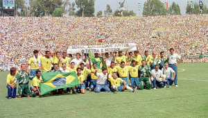 Jogadores e comissão técnica do Brasil posam após a partida final em Rose Bowl, Pasadena na Copa de 94 dos Estados Unidos Onde o Brasil venceu a Itália por 3 x 2 na disputa de pênaltis. Ao fundo uma faixa com os dizeres "Senna... aceleramos juntos, o tetra é nosso!