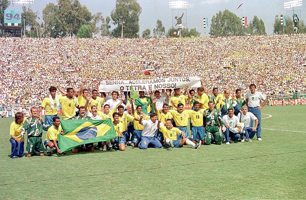 Jogadores e comissão técnica do Brasil posam após a partida final em Rose Bowl, Pasadena na Copa de 94 dos Estados Unidos Onde o Brasil venceu a Itália por 3 x 2 na disputa de pênaltis. Ao fundo uma faixa com os dizeres "Senna... aceleramos juntos, o tetra é nosso!