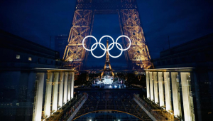 Uma foto com dupla exposição na câmera mostra a Torre Eiffel, decorada com os anéis olímpicos iluminados em Paris