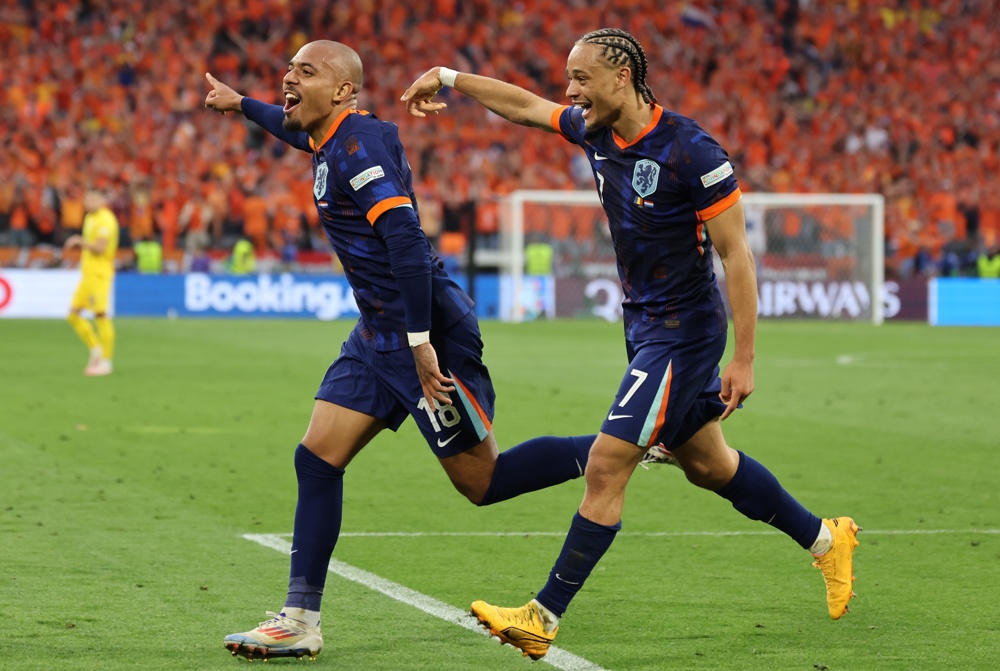 Donyell Malen da Holanda (esq.) comemora o gol de 0-3 durante a partida de futebol das oitavas de final do UEFA EURO 2024 entre Romênia e Holanda, em Munique