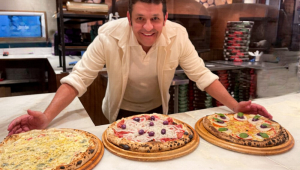 Pizzaiolo com três pizzas na mesa