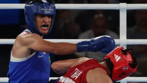 Imane Khelif, da Argélia (azul), e Janjaem Suwannapheng, da Tailândia (vermelho), em ação durante a semifinal feminina até 66 kg das competições de boxe nos Jogos Olímpicos