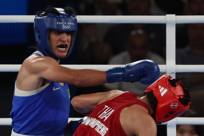 Imane Khelif, da Argélia (azul), e Janjaem Suwannapheng, da Tailândia (vermelho), em ação durante a semifinal feminina até 66 kg das competições de boxe nos Jogos Olímpicos