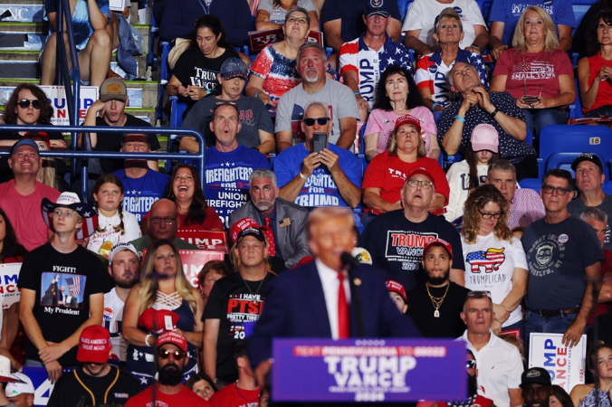 Pessoas assistem enquanto o ex-presidente dos EUA e candidato presidencial republicano Donald Trump discursa durante um comício na Mohegan Sun Arena no Casey Plaza em 17 de agosto de 2024, em Wilkes Barre, Pensilvânia