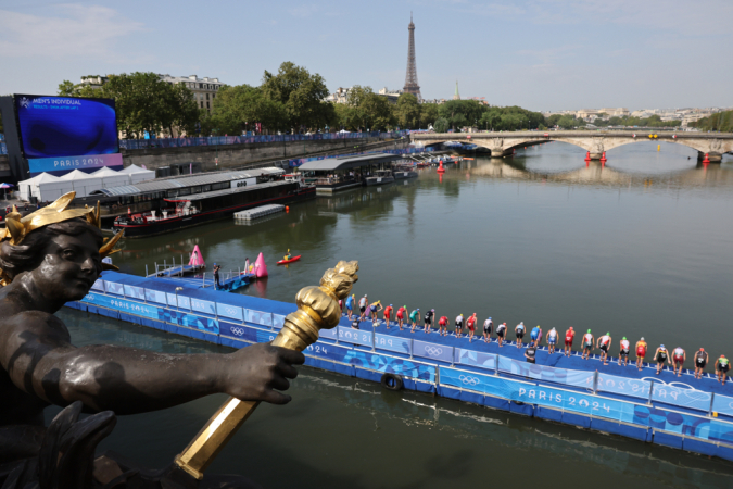 Triatletas se preparan para se lançar no Rio Sena e competir na primeira etapa do triatlo feminino dos Jogos Olímpicos de Paris