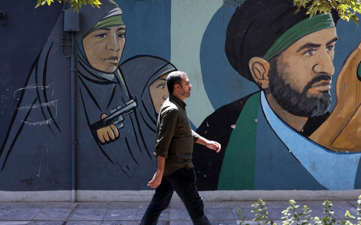 Teerã (Irã (República Islâmica do)), 19/08/2024.- Um homem iraniano passa por uma pintura de parede de soldados revolucionários iranianos na Praça Palestina em Teerã, Irã, 19 de agosto de 2024. A tensão continua alta entre o Irã e Israel desde que o falecido líder do Hamas Ismail Haniyeh foi morto em Teerã em 31 de julho de 2024, enquanto o líder iraniano, o aiatolá Khamenei, prometeu uma 