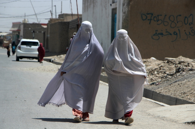 Kandahar (Afeganistão), 22/08/2024.- Mulheres afegãs vestidas com burca caminham em uma estrada em Kandahar, Afeganistão, 22 de agosto de 2024. O Talibã no Afeganistão impôs novas leis que exigem que as mulheres cubram seus corpos e rostos em público, citando essas medidas como necessárias para promover a virtude e prevenir o vício, disse o Ministério para a Propagação da Virtude e Prevenção do Vício. Aprovadas por seu Líder Supremo Hibatullah Akhundzada, as regulamentações incluem restrições às vozes das mulheres em público, a proibição de imagens de seres vivos e proibições de música e interações entre gêneros mistos. As medidas atraíram críticas da Organização das Nações Unidas (ONU) por fomentar o medo e a intimidação, especialmente entre mulheres e meninas, à medida que o Ministério para a Propagação da Virtude e Prevenção do Vício do Talibã expande seu controle sobre a vida pública. (Afganistán)