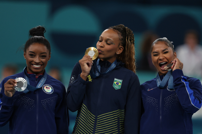 A ginasta brasileira Rebeca Andrade (c), ouro; e as americanas Simone Biles (e), prata, e Jordan Chiles (d), bronze, posam durante a cerimônia de entrega de medalhas da final de solo feminino de ginástica artística