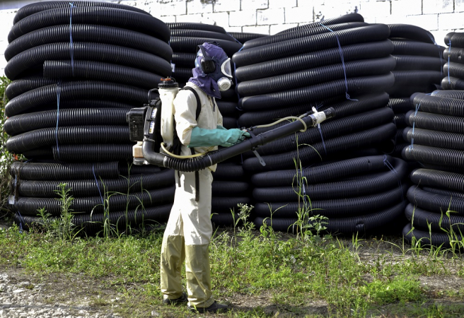 Agente da Prefeitura de São José dos Campos (SP) aplica inseticida de baixa toxicidade para eliminar o mosquito transmissor da dengue em galpão de materiais hidráulicos na zona central da cidade