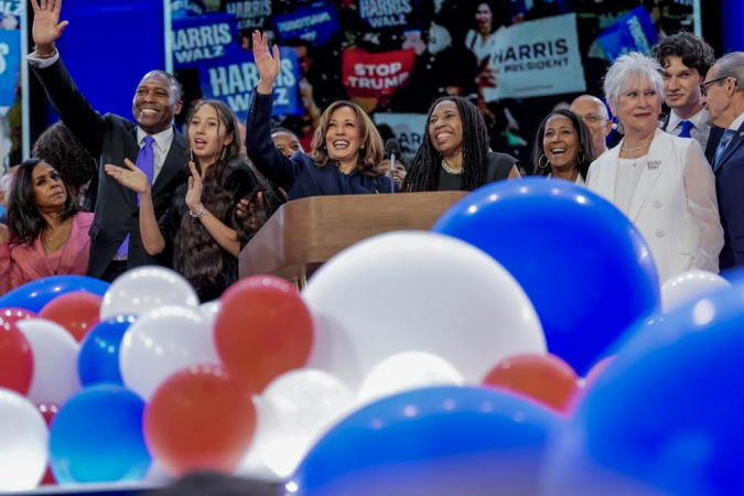 A candidata presidencial democrata e vice-presidente dos EUA, Kamala Harris (C), acena no palco com membros da família após seu discurso durante a última noite da Convenção Nacional Democrata