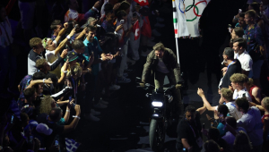 O ator americano Tom Cruise carrega a bandeira olímpica em uma motocicleta durante a Cerimônia de Encerramento dos Jogos Olímpicos de Paris 2024