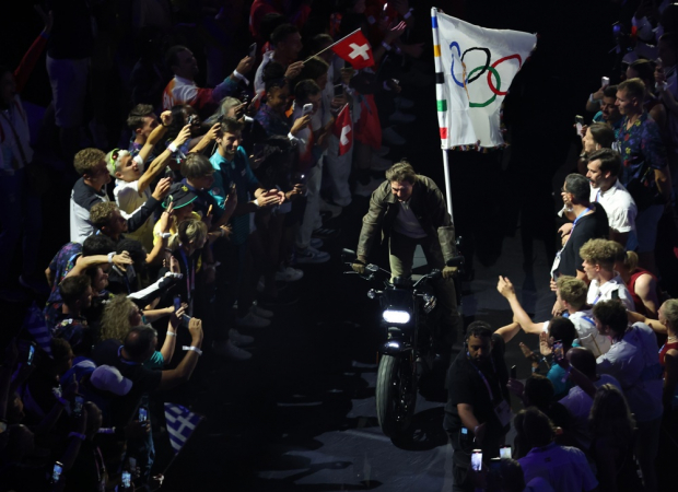 O ator americano Tom Cruise carrega a bandeira olímpica em uma motocicleta durante a Cerimônia de Encerramento dos Jogos Olímpicos de Paris 2024